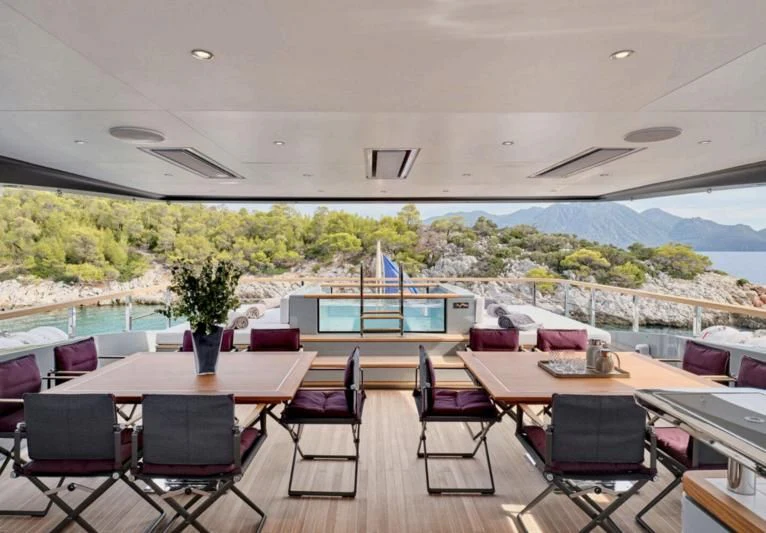 a room with tables and chairs aboard PARA BELLVM Yacht for Charter