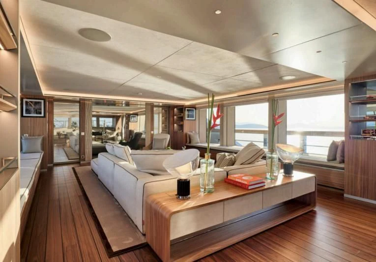 a room with a large bed and a table with chairs aboard PARA BELLVM Yacht for Charter