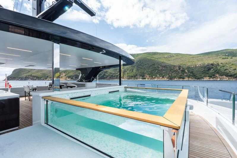 a swimming pool next to a large building with a large roof aboard PARA BELLVM Yacht for Charter