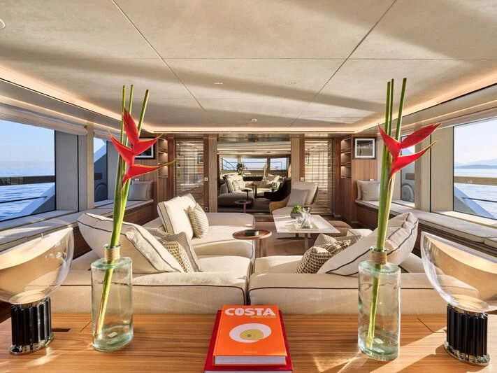 a table with chairs and a vase with flowers in it aboard PARA BELLVM Yacht for Charter
