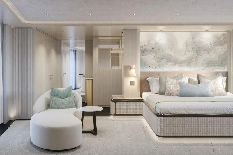 a modern bedroom with a bed and a chair aboard PARA BELLVM Yacht for Charter