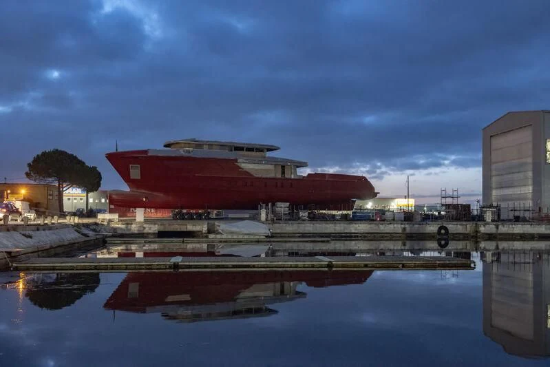a large container ship docked at a port aboard PARA BELLVM Yacht for Charter