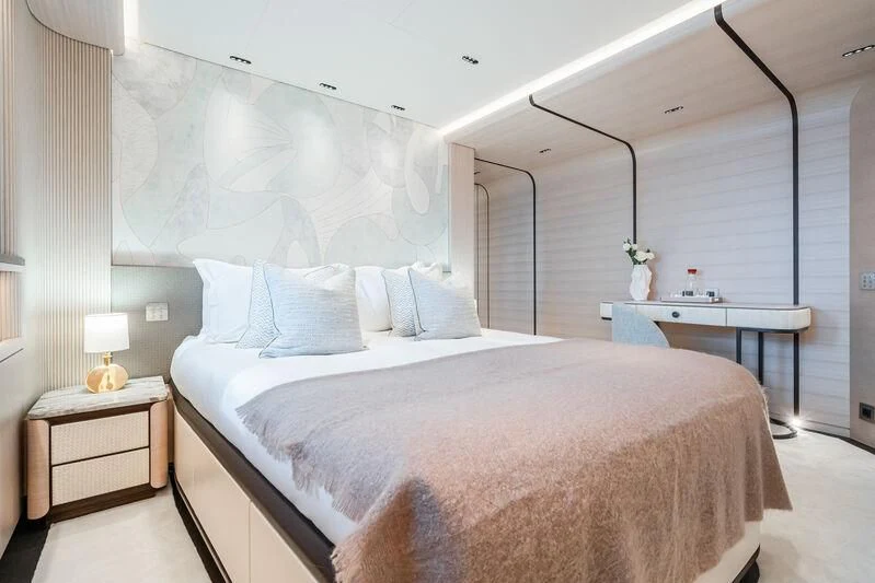 a bedroom with a bed and a table aboard PARA BELLVM Yacht for Charter