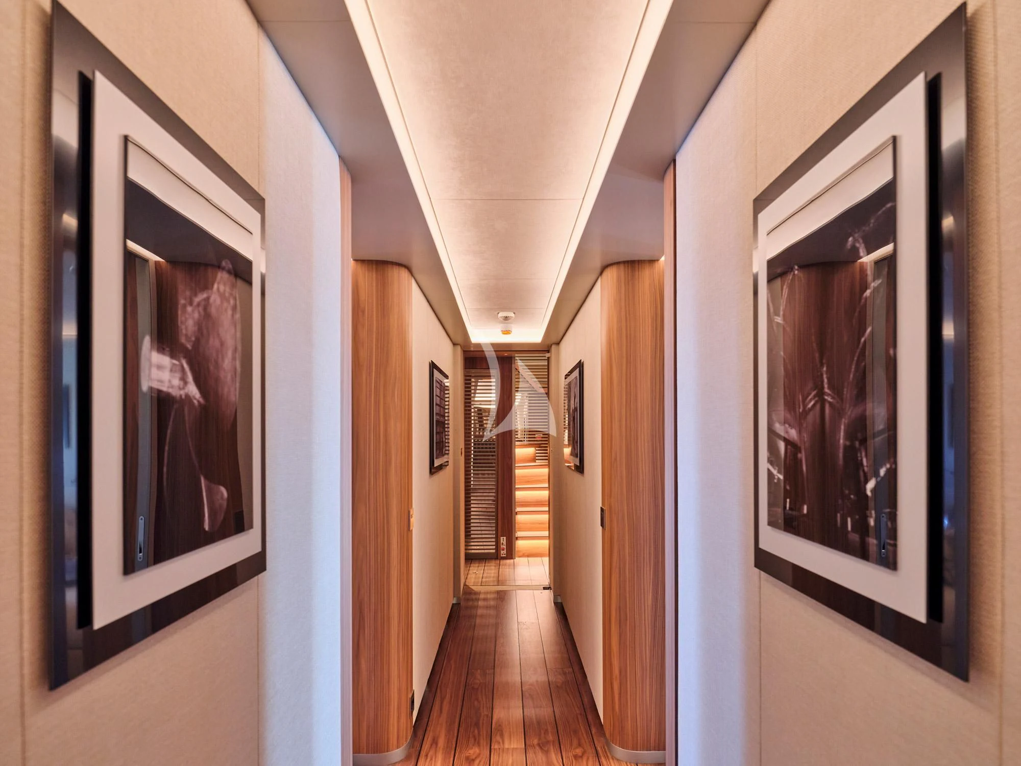 a hallway with a wood floor and framed paintings on the wall aboard PARA BELLVM Yacht for Charter