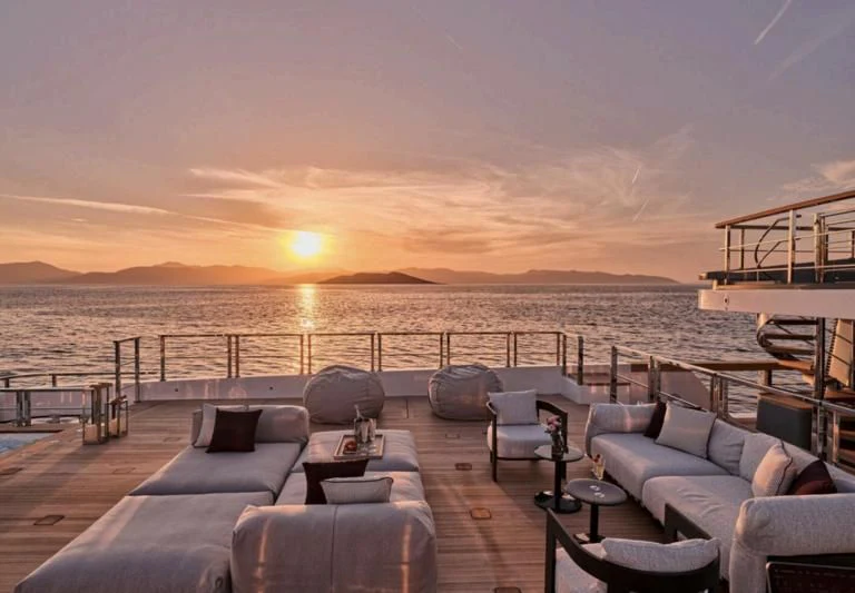 a deck with chairs and a body of water in the background aboard PARA BELLVM Yacht for Charter