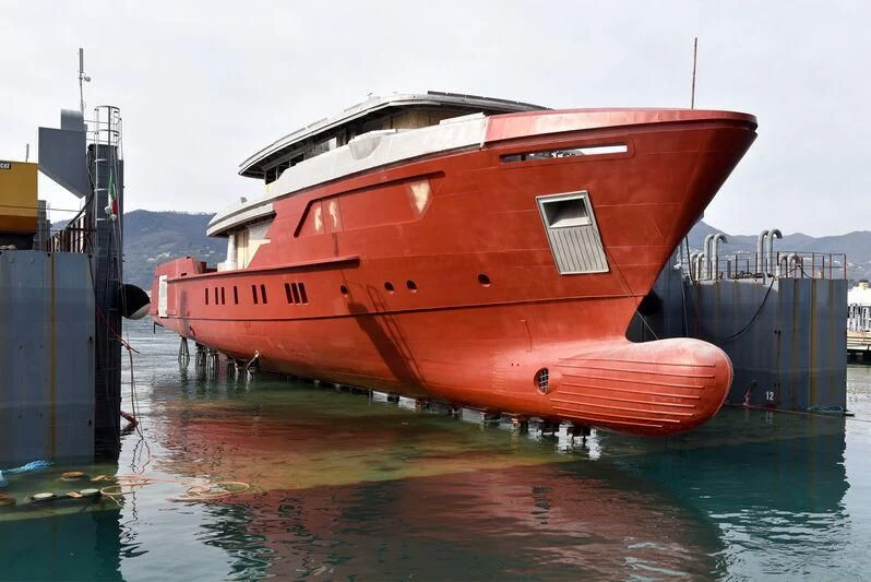 a large red boat on a dock aboard PARA BELLVM Yacht for Charter
