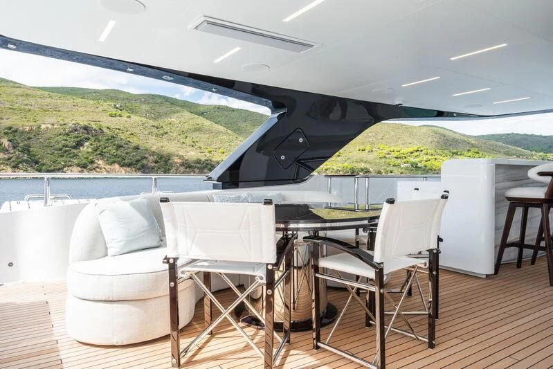 a lounge chair on a deck overlooking a body of water aboard PARA BELLVM Yacht for Charter