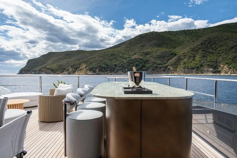 a table on a deck overlooking a body of water aboard PARA BELLVM Yacht for Charter