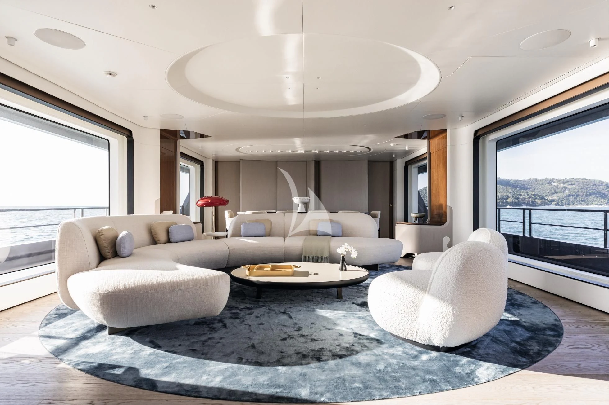 a living room with a large blue rug and white couches aboard LUZ DE MAR Yacht for Sale