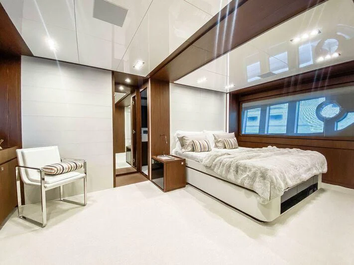 a large bedroom with a bed and a chair aboard EVENFLOW Yacht for Sale