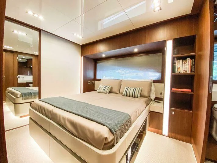a bedroom with a bed and a bookcase aboard EVENFLOW Yacht for Sale