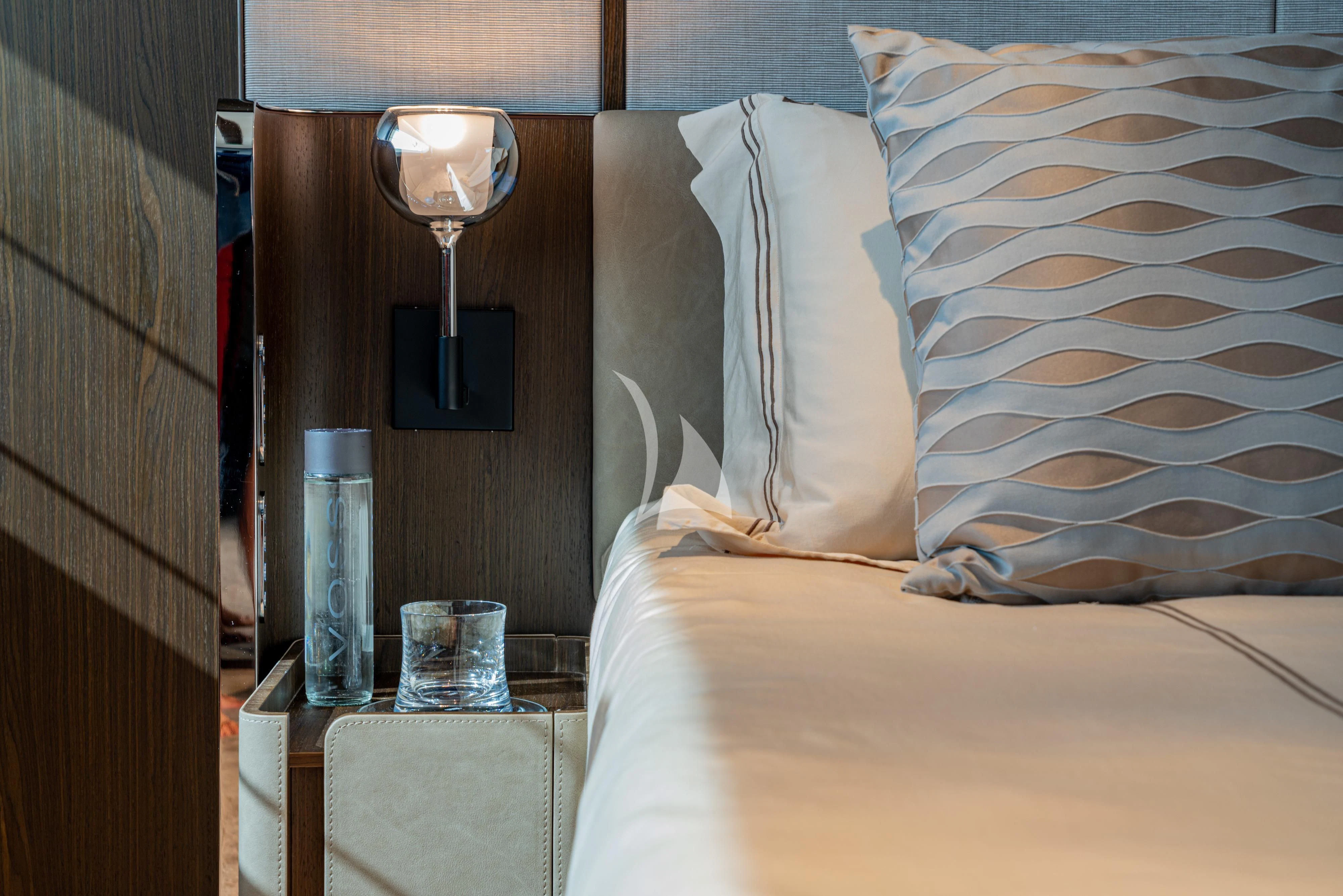 a bed with a lamp and a bottle of water on it aboard VITTORIA Yacht for Sale