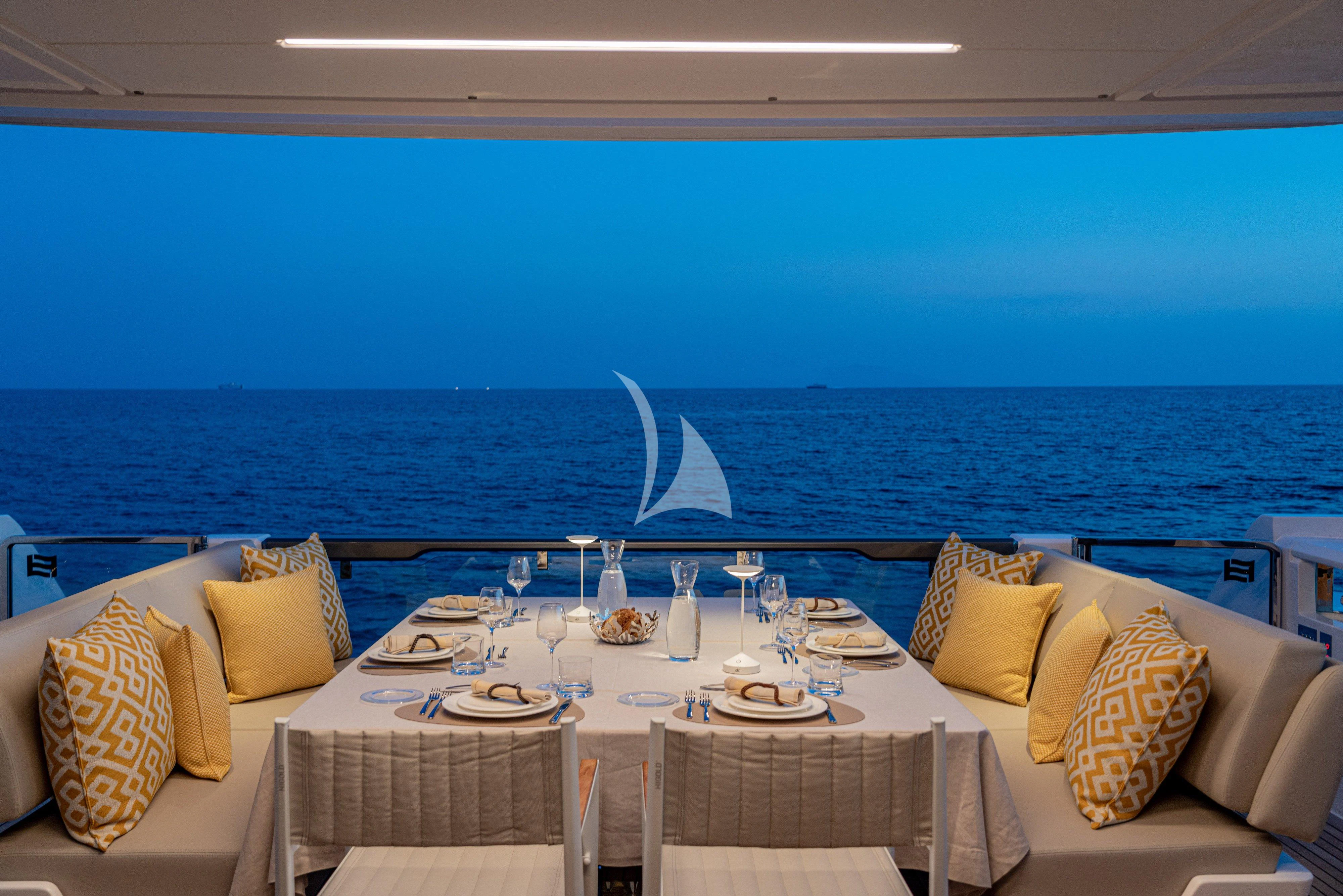 a table set for a meal on the beach aboard VITTORIA Yacht for Sale