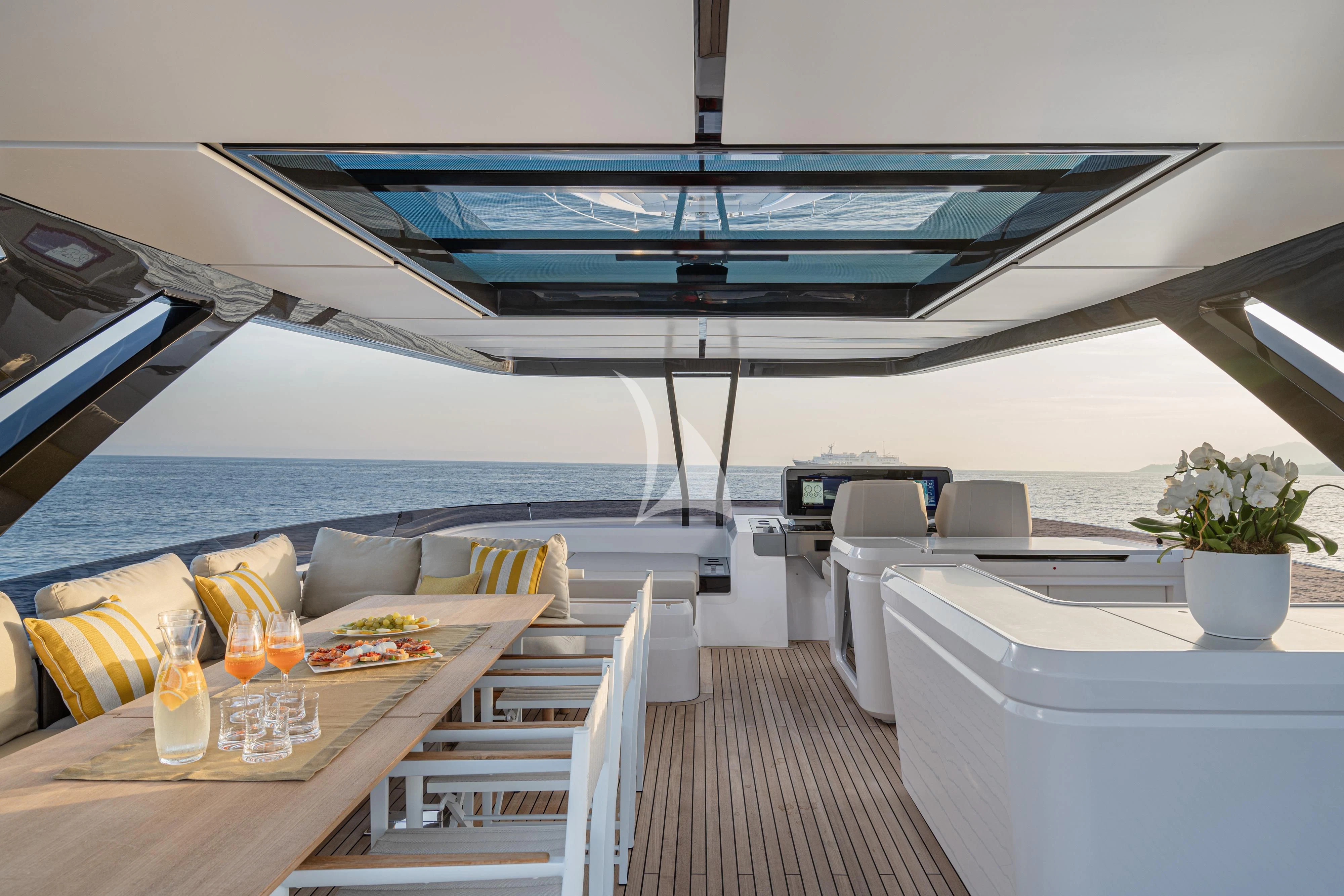 a room with a large bed and a table with chairs and a large pool aboard VITTORIA Yacht for Sale