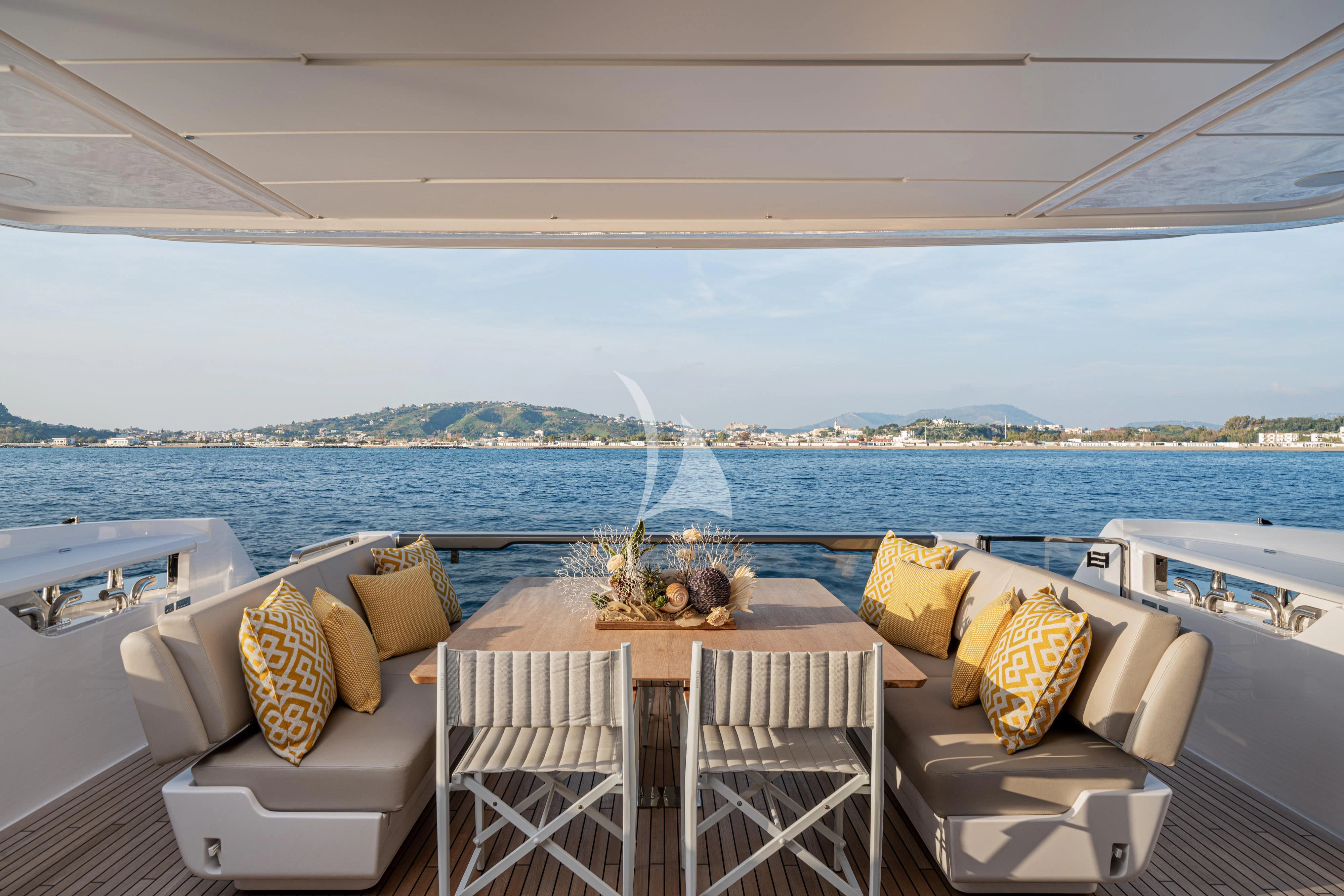 a table and chairs on a balcony overlooking a body of water aboard VITTORIA Yacht for Sale
