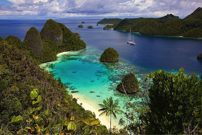 a beach with a body of water and a boat in it aboard ETHEREAL Yacht for Sale
