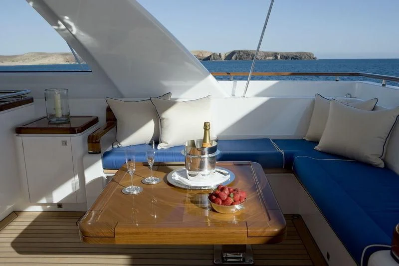 a boat with a table and a glass of wine on a boat aboard ETHEREAL Yacht for Sale