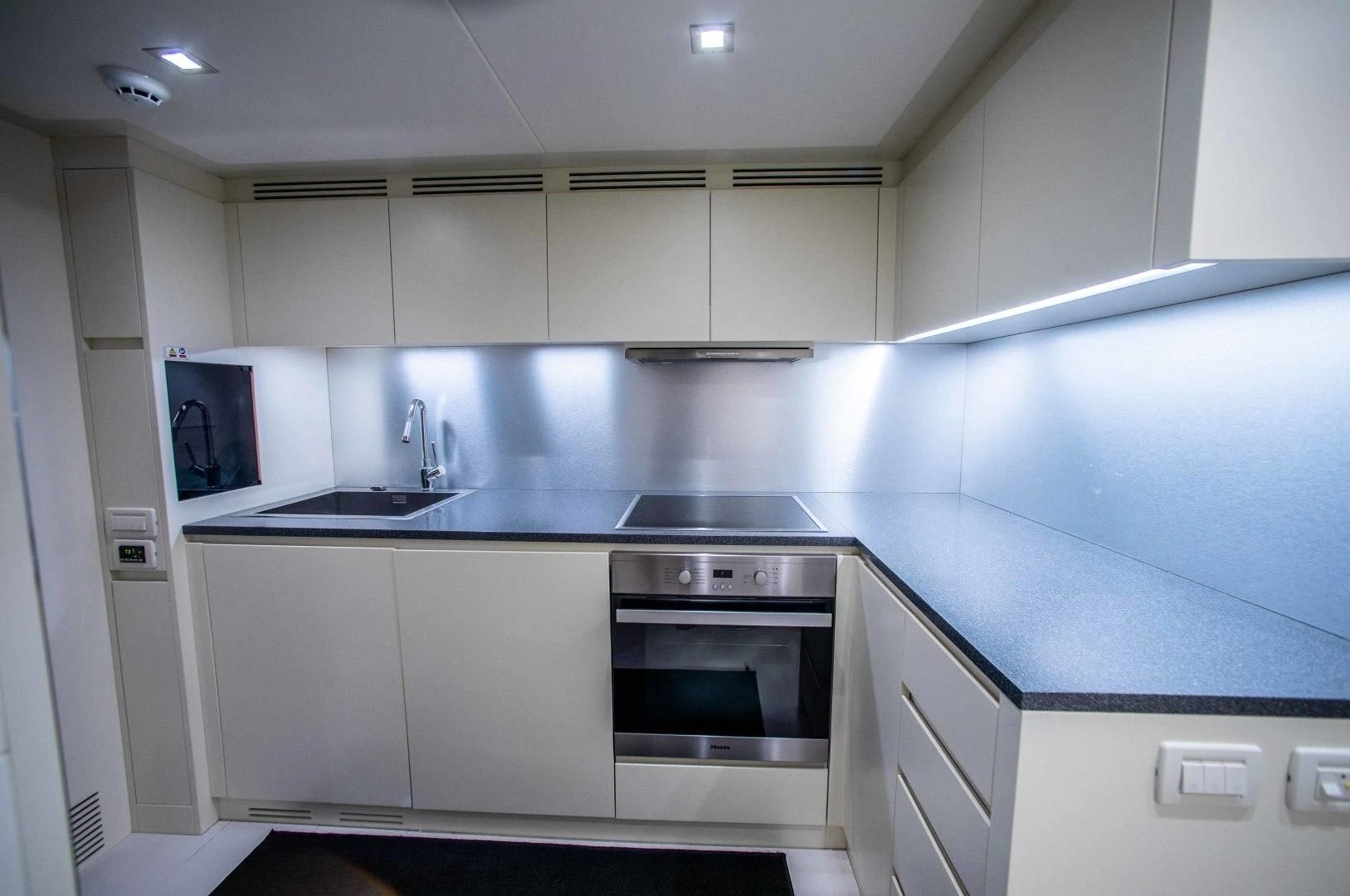 a kitchen with a black stove aboard AFRICAN WILD DOG Yacht for Sale