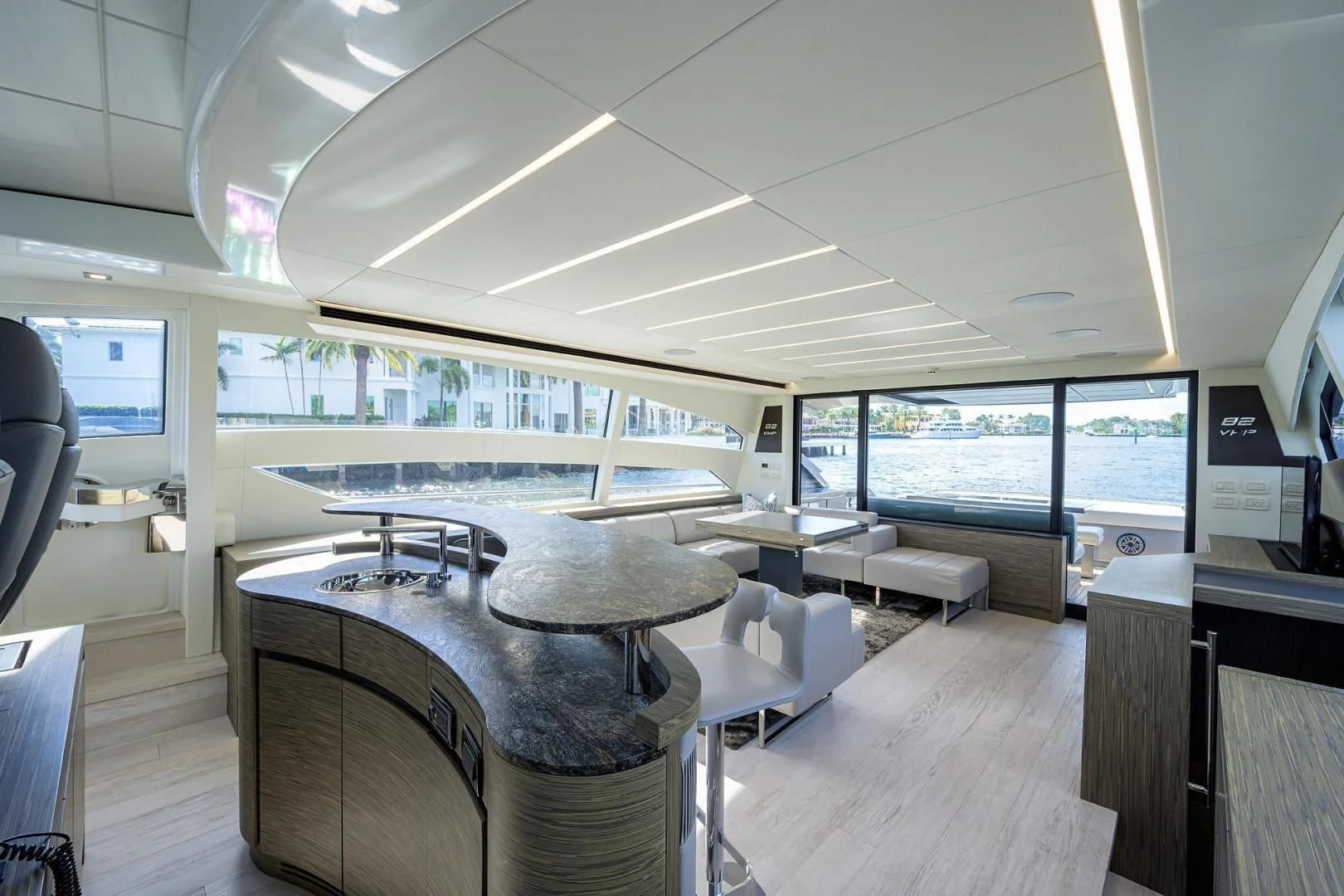 a room with a large window and a table with chairs and a large television screen aboard AFRICAN WILD DOG Yacht for Sale