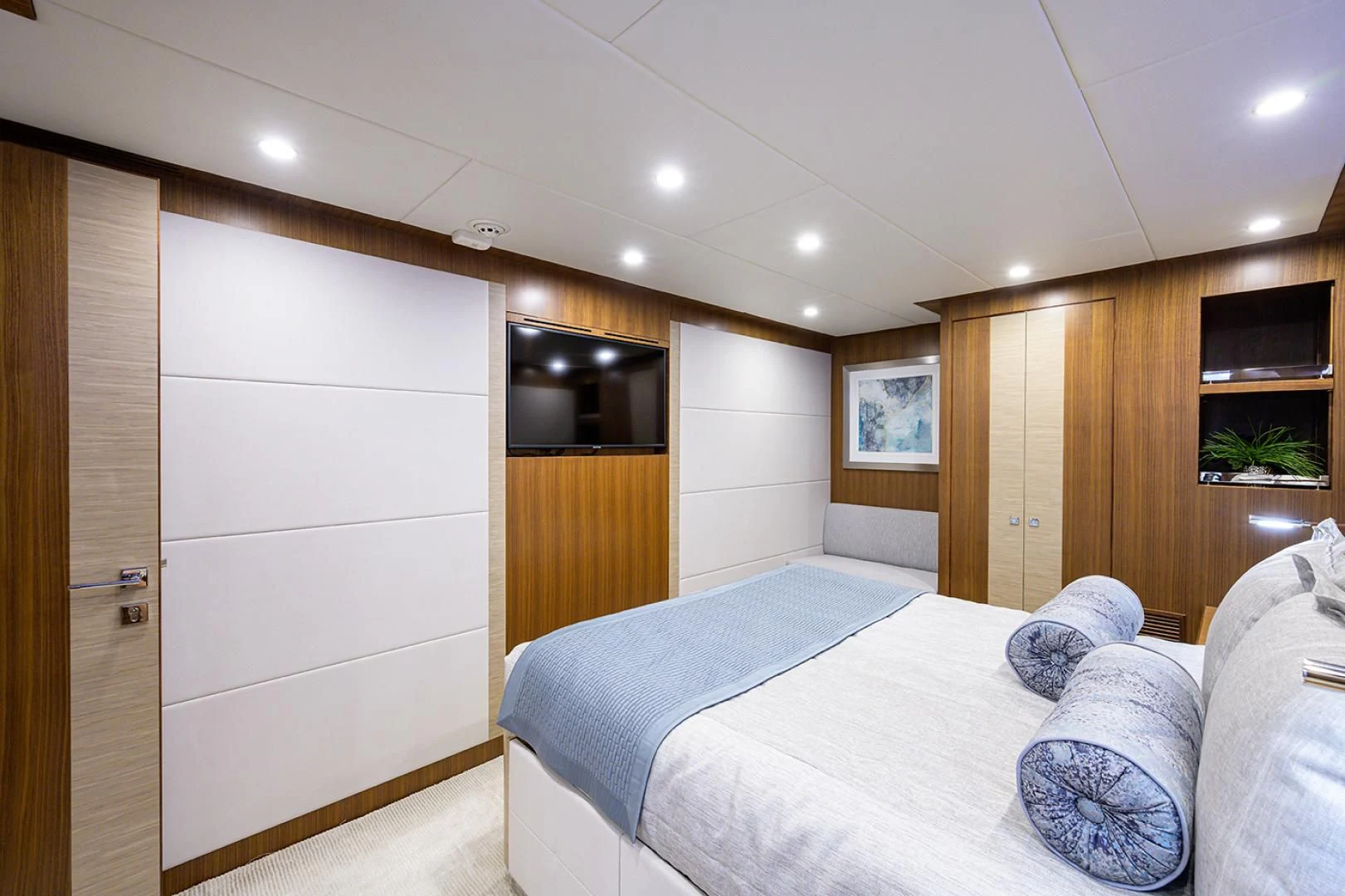 a bedroom with a bed and a tv aboard RISK TAKER Yacht for Charter