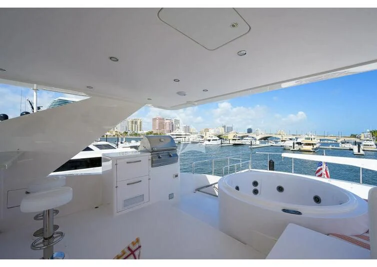 a large white bathtub in a room with a large window and a view of the city aboard RISK TAKER Yacht for Charter
