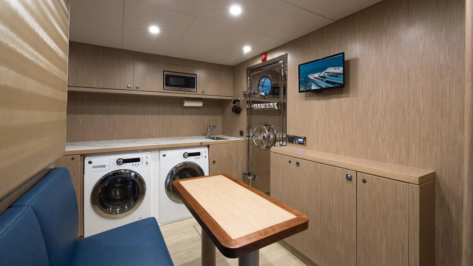 a kitchen with a washing machine and a table aboard RISK TAKER Yacht for Charter