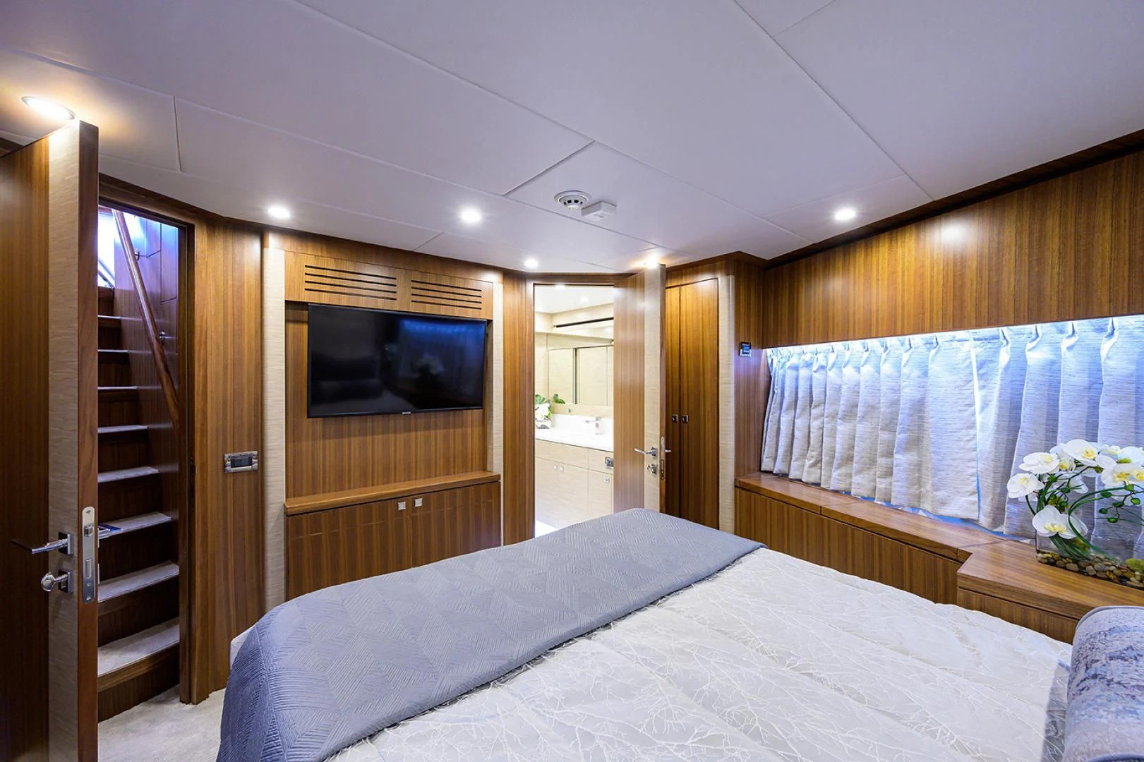 a bedroom with a bed and a television aboard RISK TAKER Yacht for Charter
