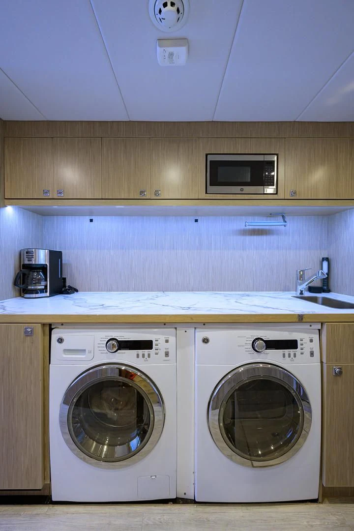 a white washing machine in a kitchen aboard RISK TAKER Yacht for Charter