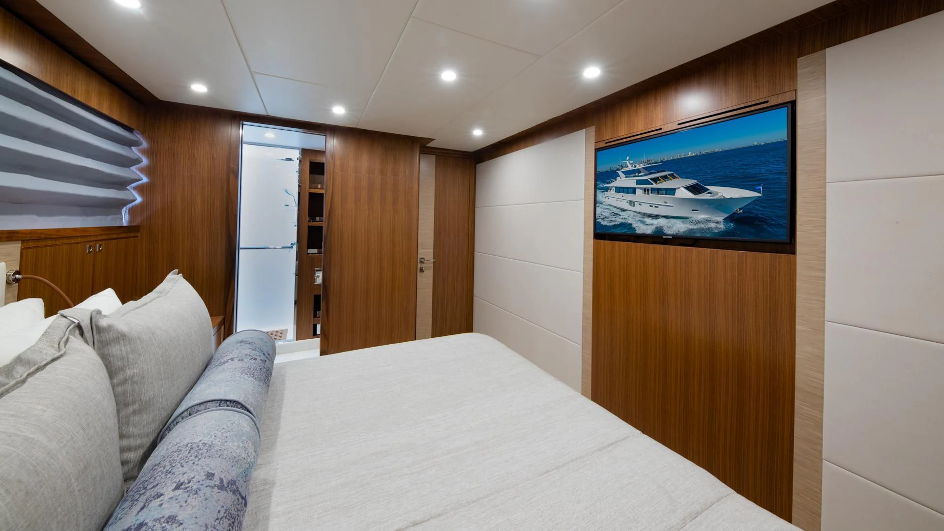 a bed with a white sheet and pillows in a room with wood walls aboard RISK TAKER Yacht for Charter