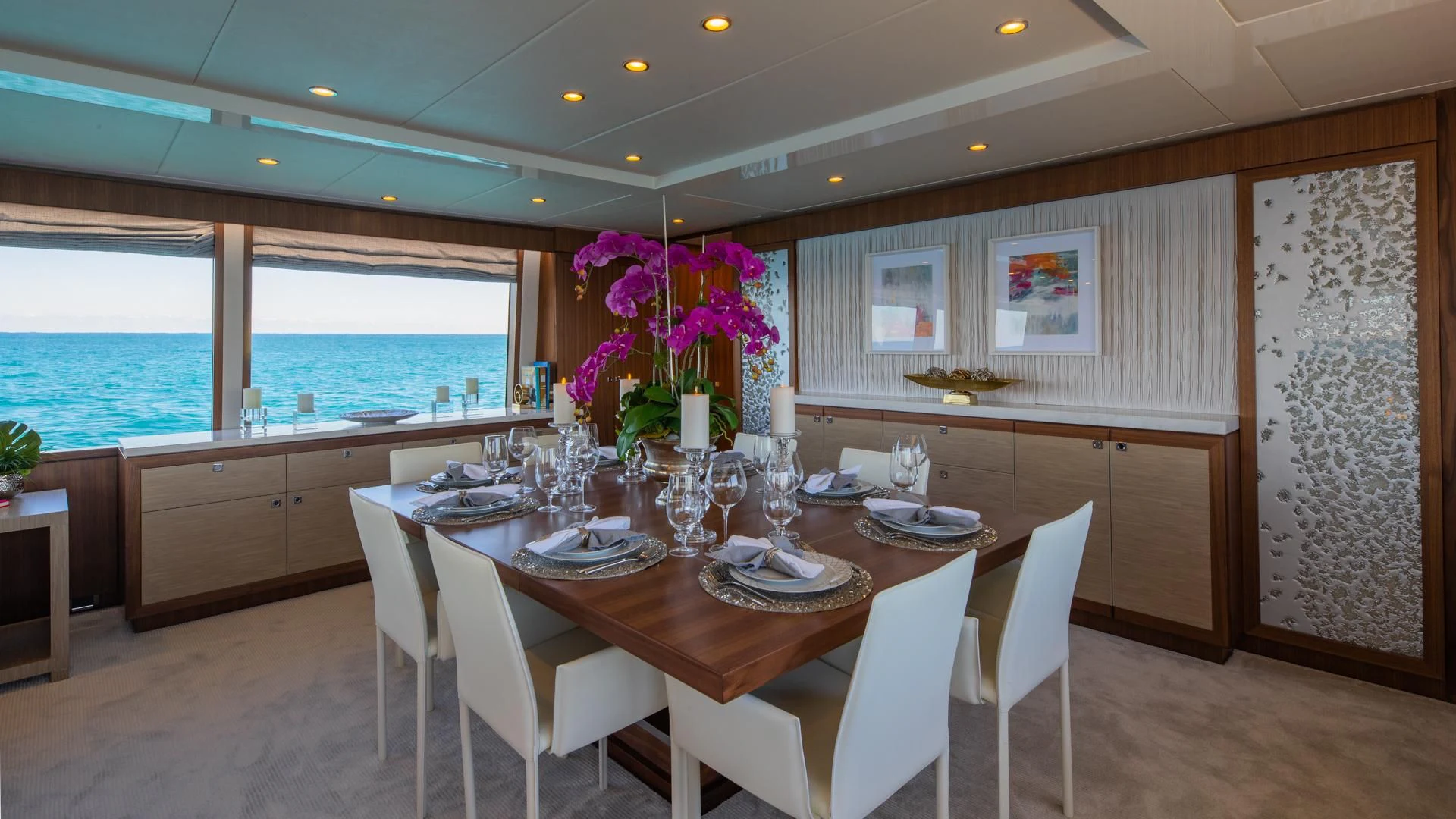 a large dining table with white chairs and white chairs aboard RISK TAKER Yacht for Charter