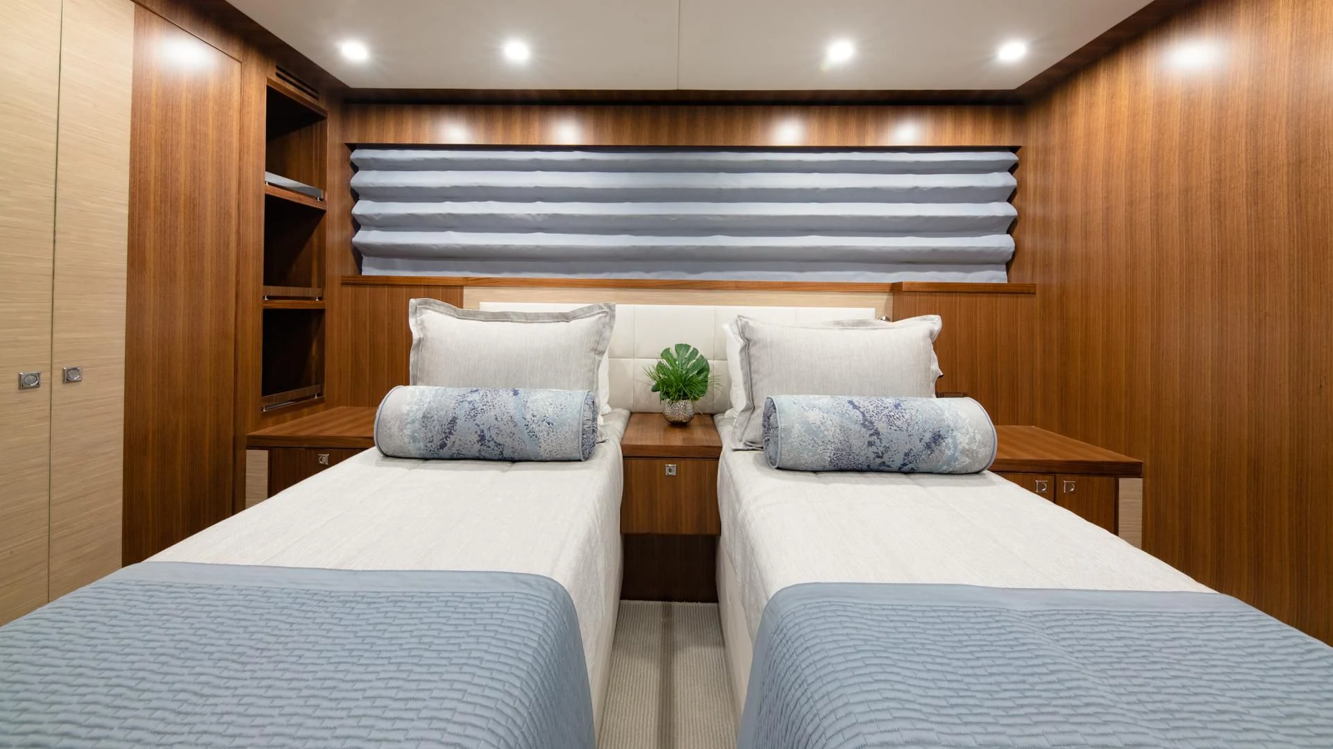 a room with beds and a plant aboard RISK TAKER Yacht for Charter