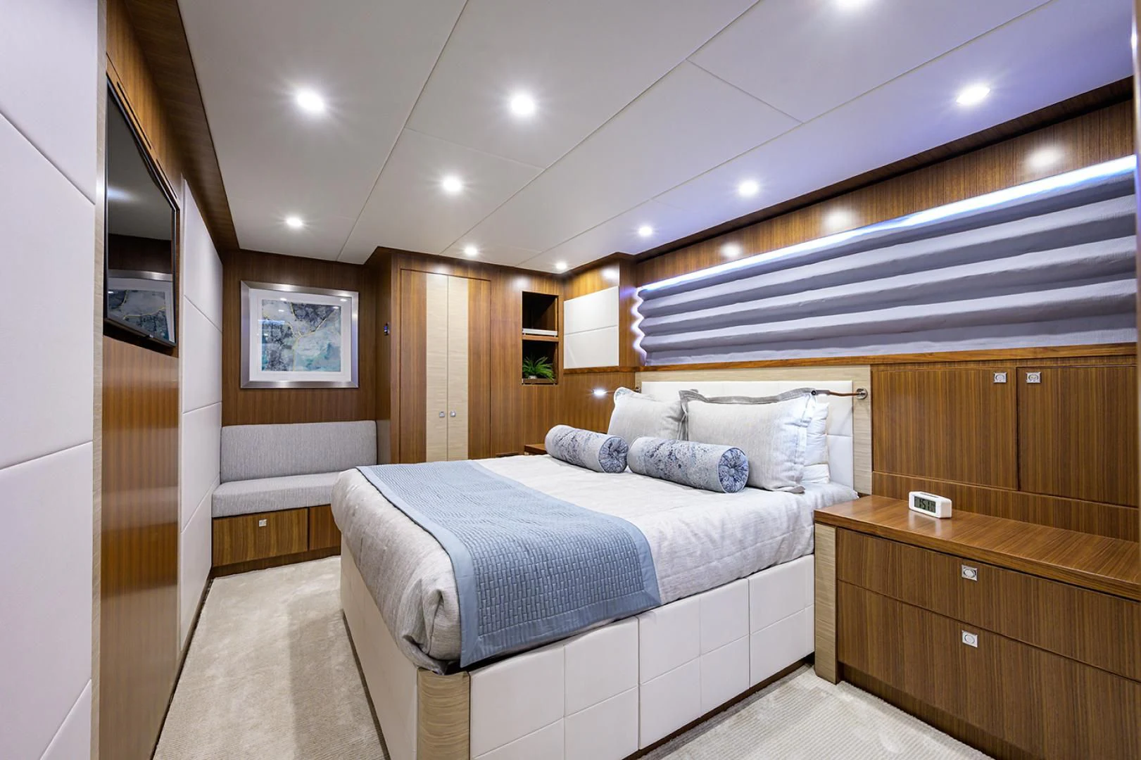 a bedroom with a bed and a wood cabinet aboard RISK TAKER Yacht for Charter
