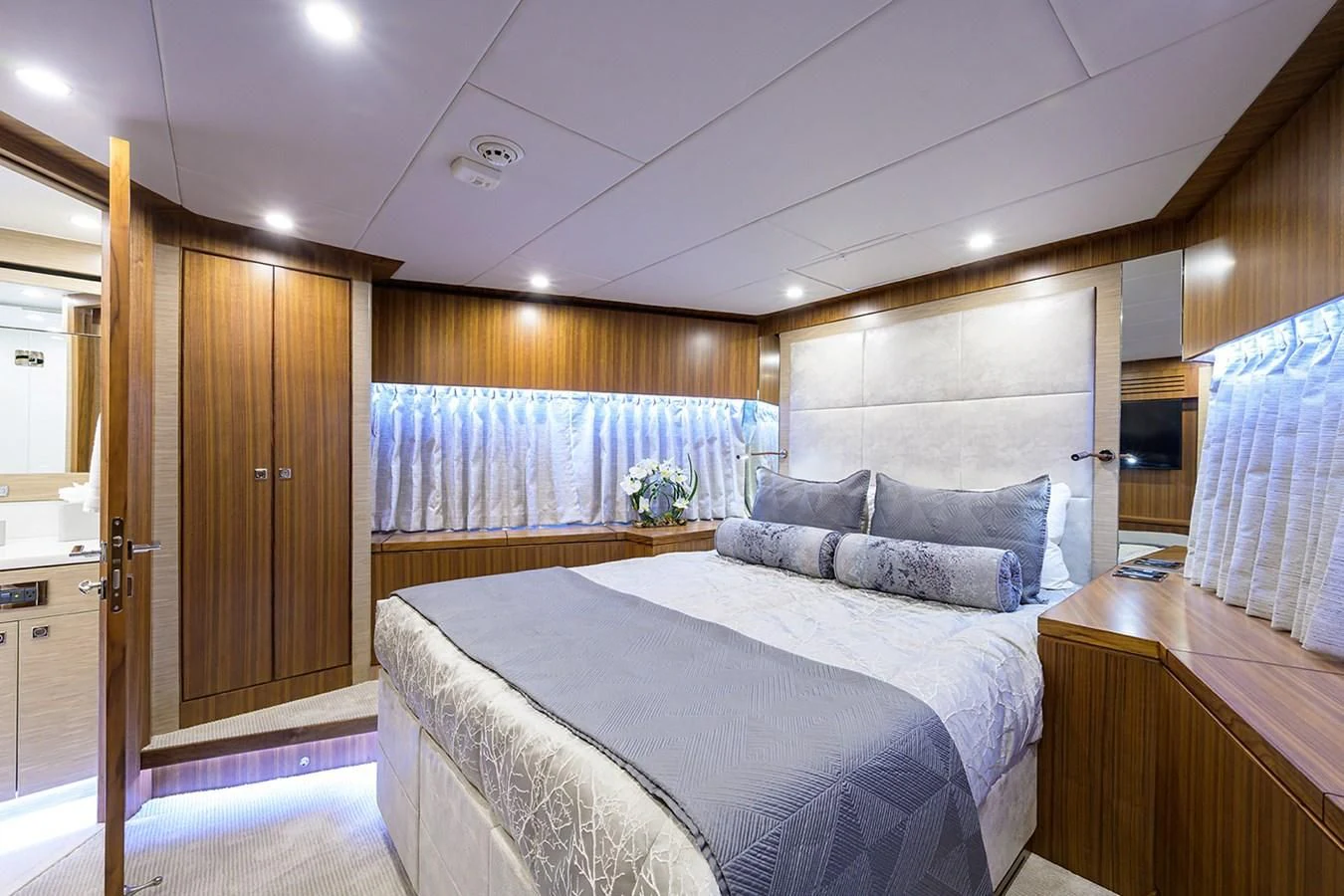 a bedroom with a bed and a desk aboard RISK TAKER Yacht for Charter