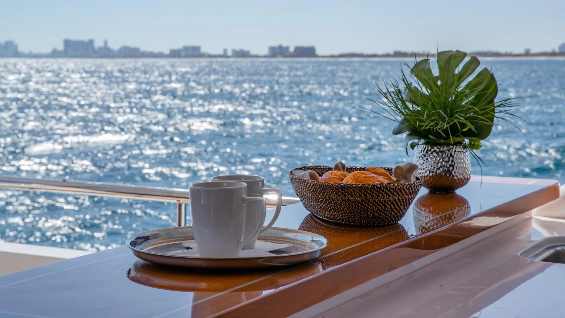 a cup of coffee on a table overlooking a body of water aboard RISK TAKER Yacht for Charter