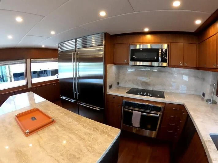 a kitchen with a stainless steel refrigerator aboard RISK TAKER Yacht for Charter