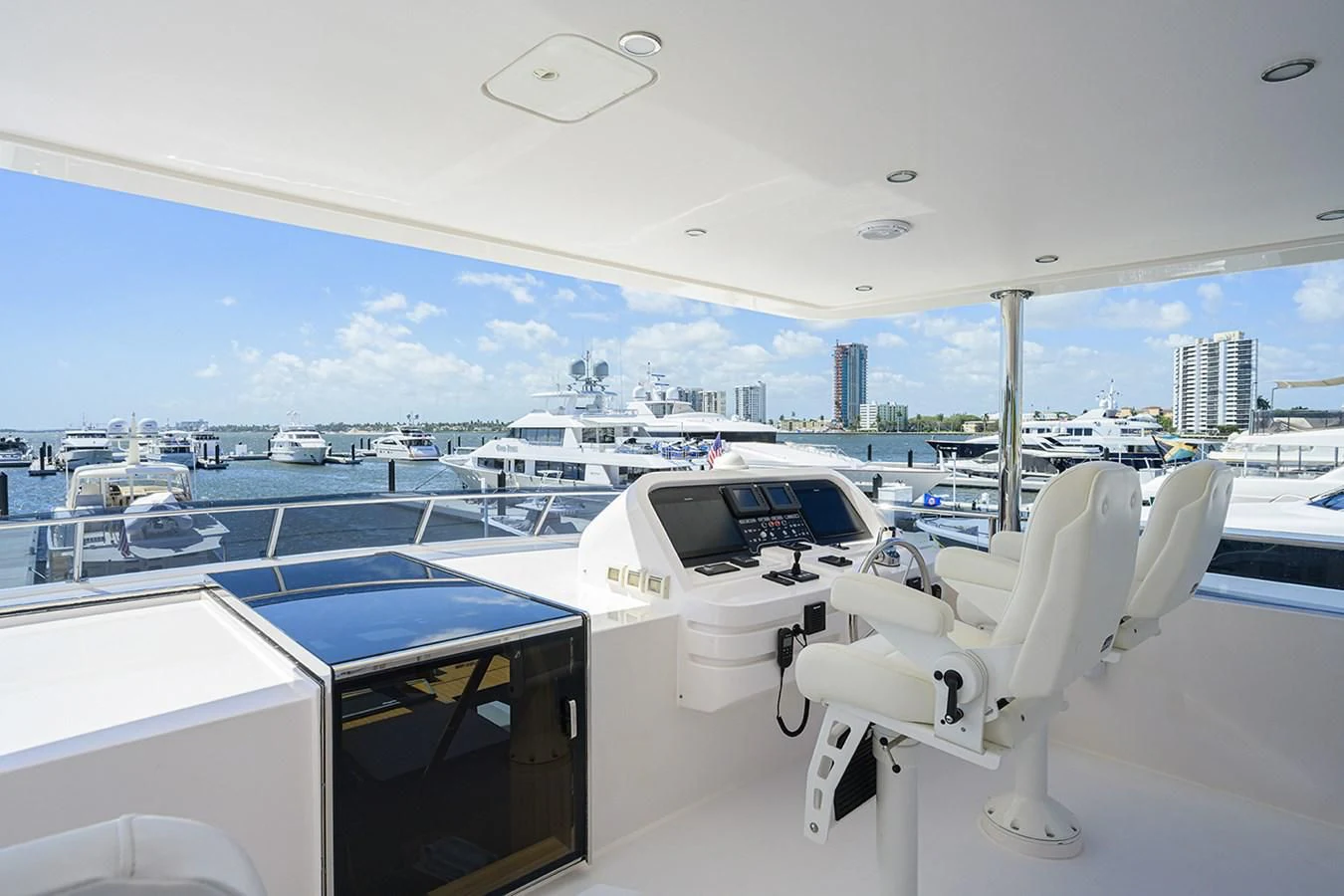 a white chair on a deck overlooking a marina with boats aboard RISK TAKER Yacht for Charter
