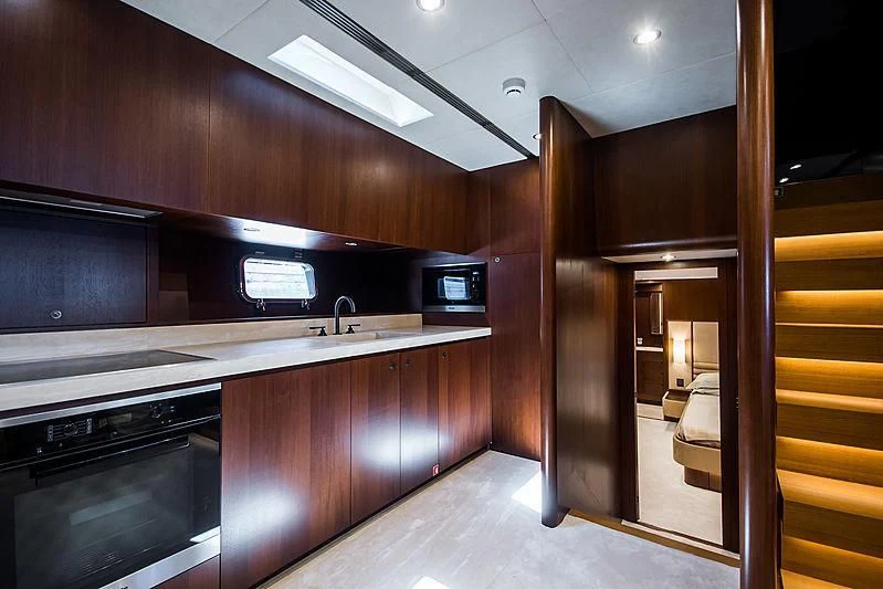 a kitchen with wooden cabinets aboard CARA MONTANA Yacht for Sale