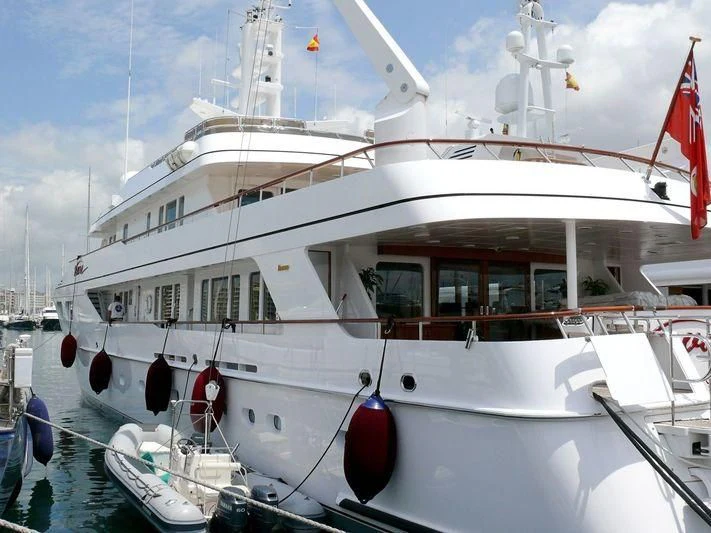 a white boat with red flags aboard VAVA Yacht for Sale