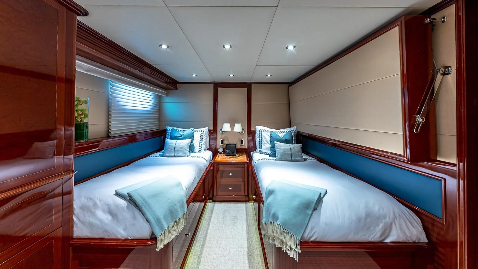 a room with beds and a chair aboard KASHMIR Yacht for Charter