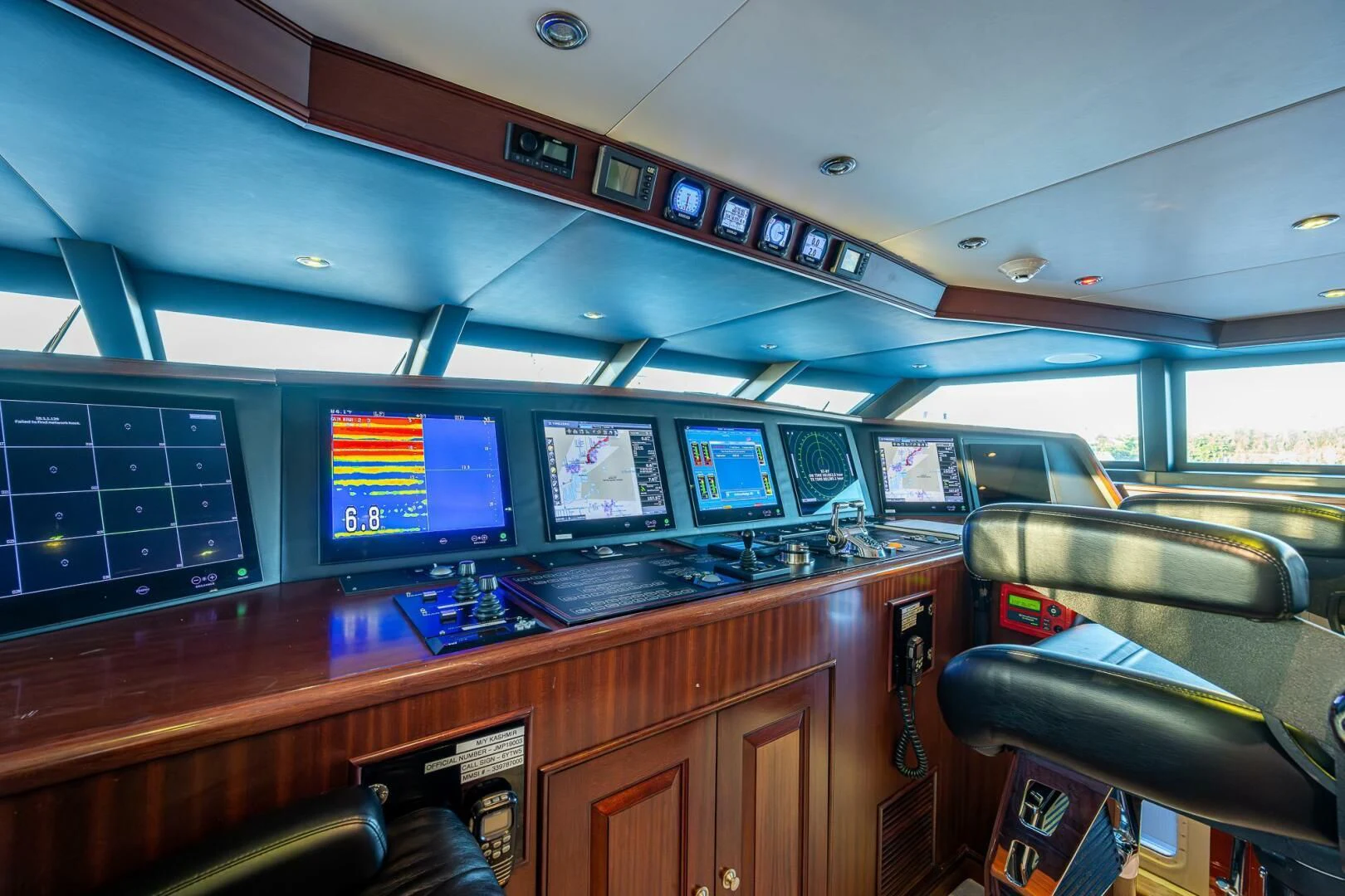 a row of computer screens on a wooden desk aboard KASHMIR Yacht for Charter