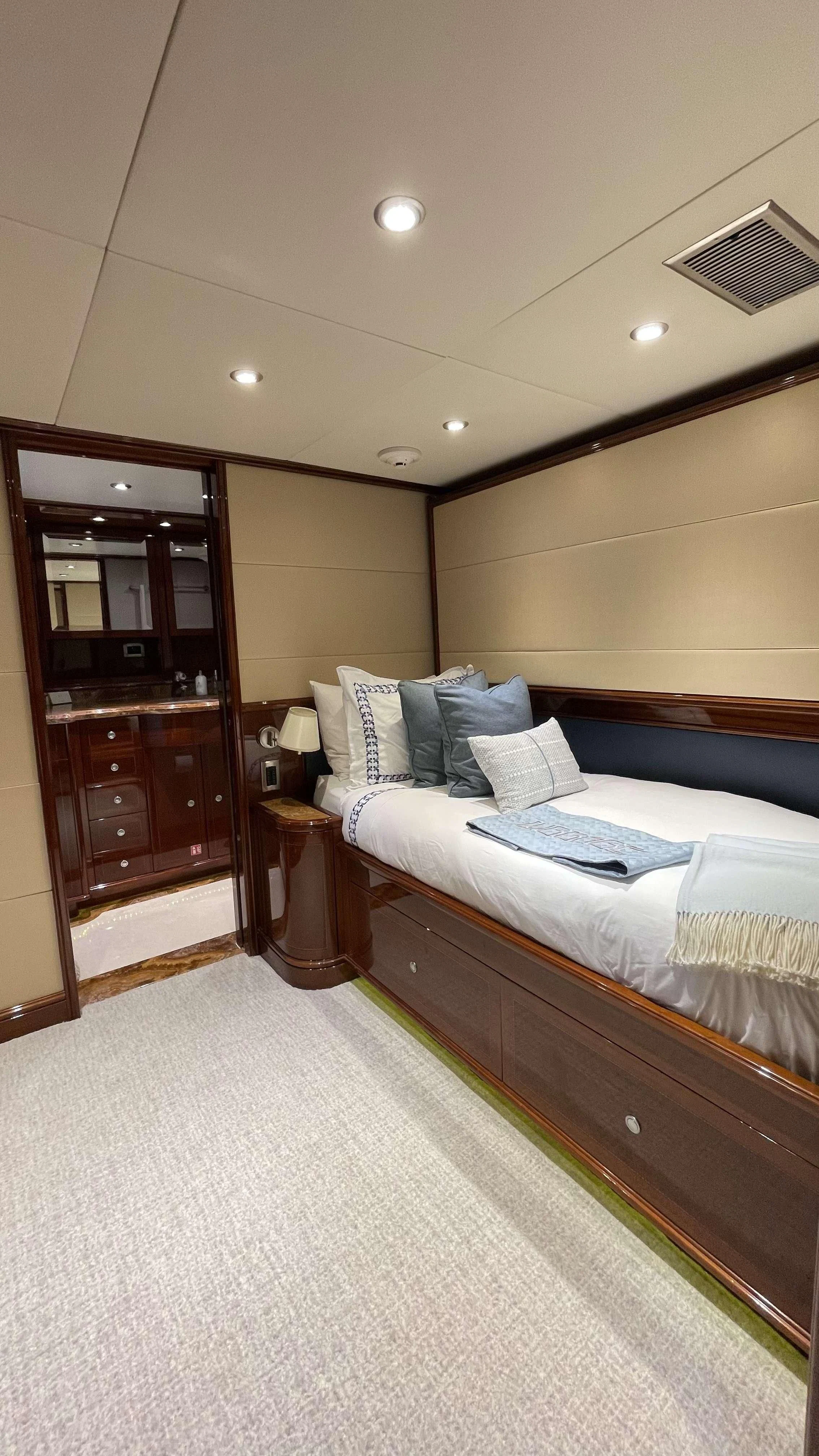 a bedroom with a bed and a mirror aboard KASHMIR Yacht for Charter