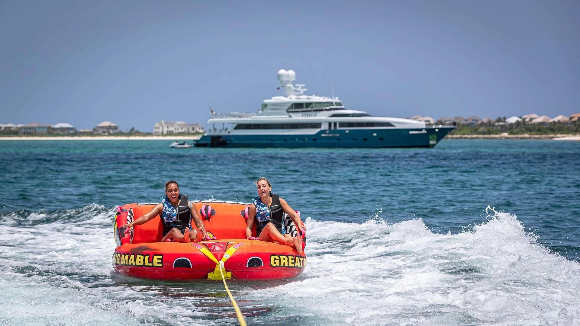 two people in a raft in the water with a boat in the background aboard KASHMIR Yacht for Charter