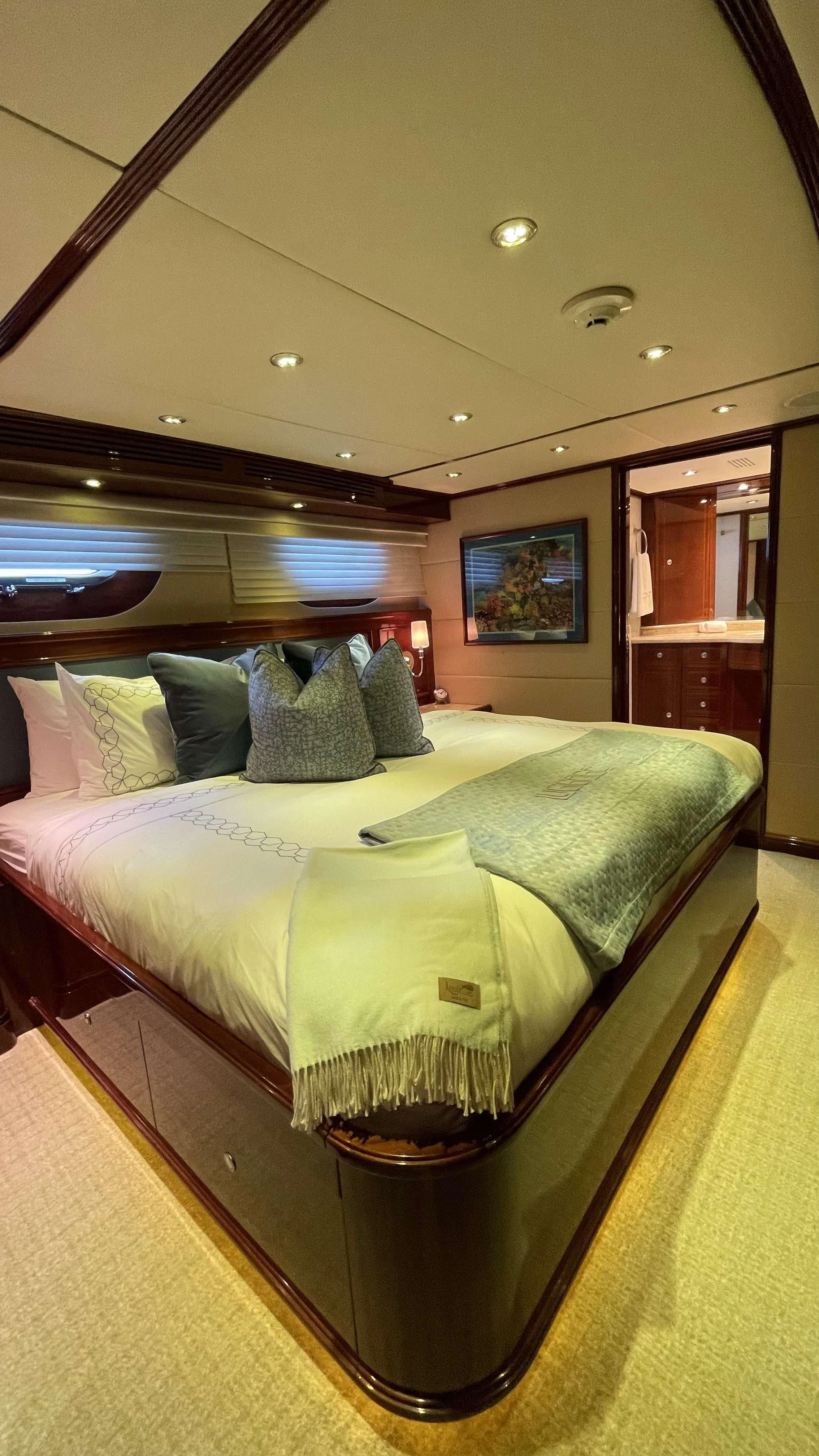 a bed with a large mirror above it aboard KASHMIR Yacht for Charter