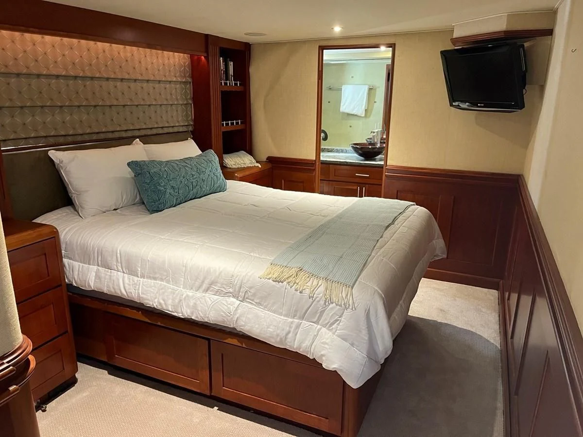 a bed with a television on the wall aboard SEAQUEST Yacht for Sale