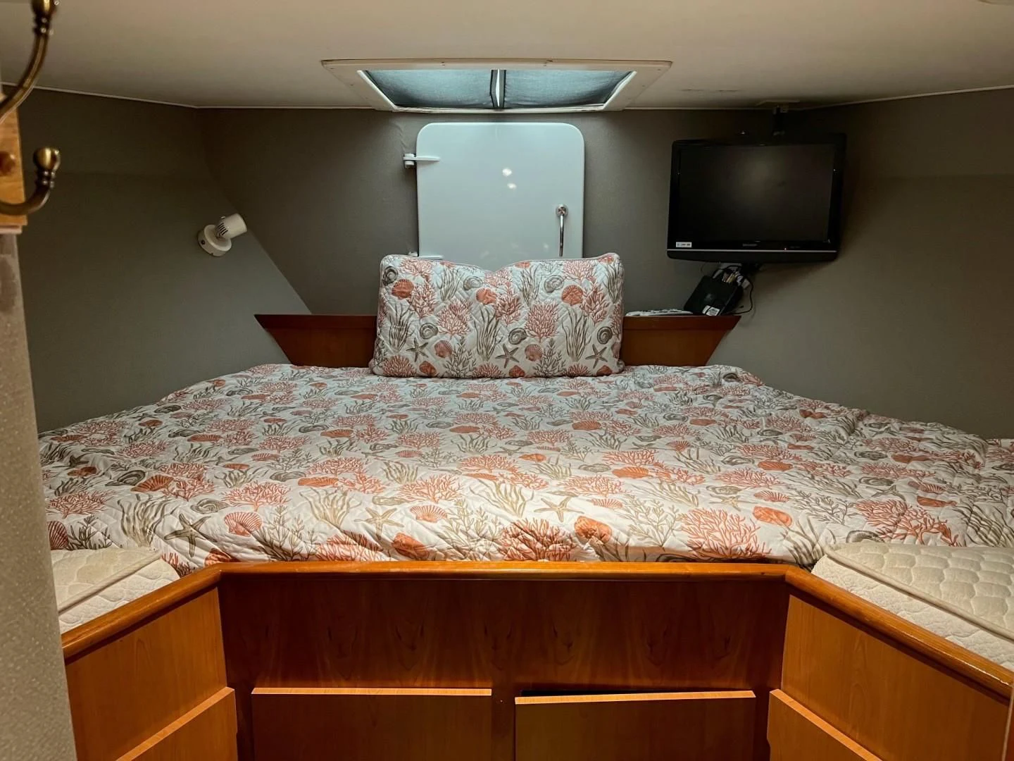 a bed with a television on the wall aboard SEAQUEST Yacht for Sale