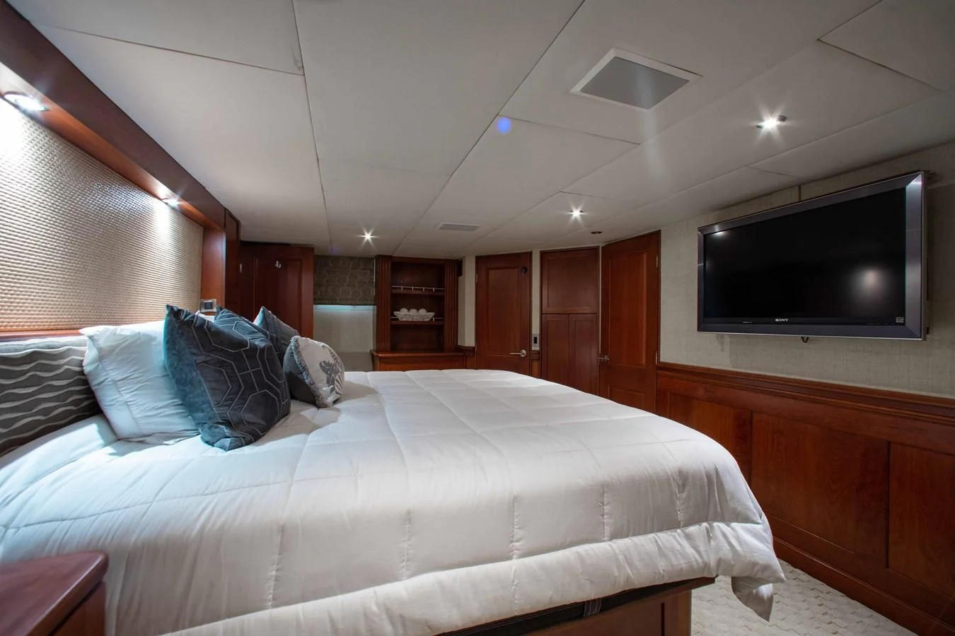 a bed with pillows and a television aboard SEAQUEST Yacht for Sale