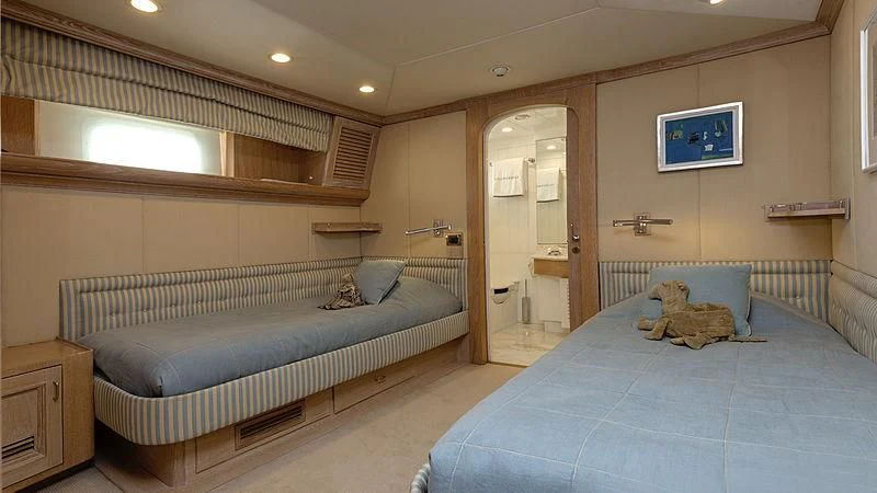 a bedroom with a bed and a television on the wall aboard NATALIA V Yacht for Sale