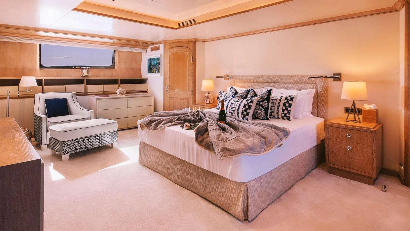 a bedroom with a bed and a chair aboard NATALIA V Yacht for Sale