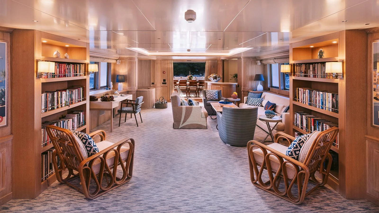 a room with a few chairs and a table with books on it aboard NATALIA V Yacht for Sale