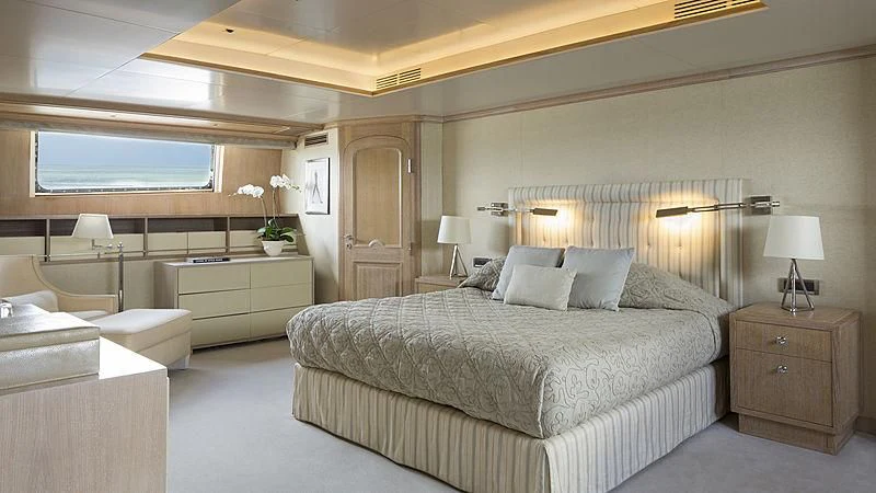 a bedroom with a bed and a desk aboard NATALIA V Yacht for Sale